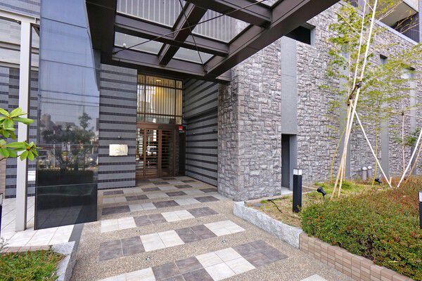 アプローチには天然石細粒固着仕上げと呼ばれる床材を採用しています。		