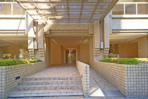 エントランスには階段とスロープ、格子状のデザインの長い庇がアクセントに。 エントランスには階段とスロープ、格子状のデザインの長い庇がアクセントに。