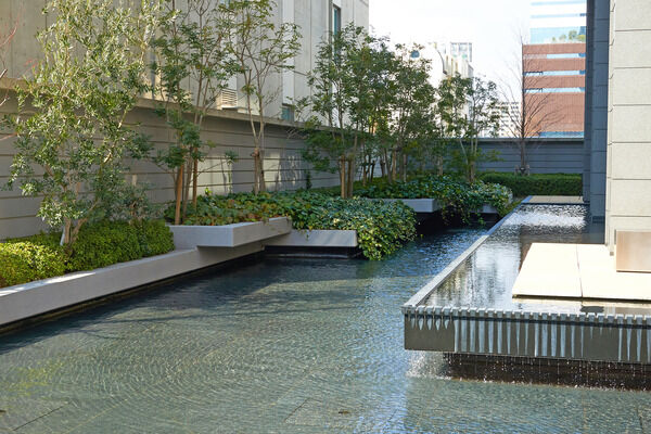 建物の周囲は水と緑が配され、エントランスホールは壮大な2層吹抜け。		