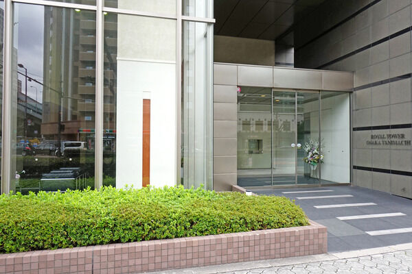 【ロイヤルタワー大阪谷町】アプローチは、低木の植栽が落ち着いた雰囲気を添えています。		