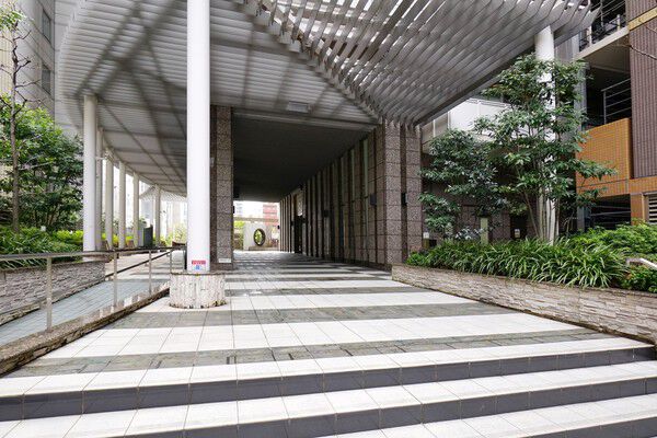 アプローチの天井は光が差し込む格子状のデザイン。開放的で明るい空間です。		