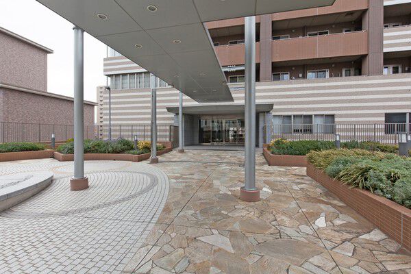 乱張りの石とタイルが、まるで庭園のような気品を漂わせるエントランス。