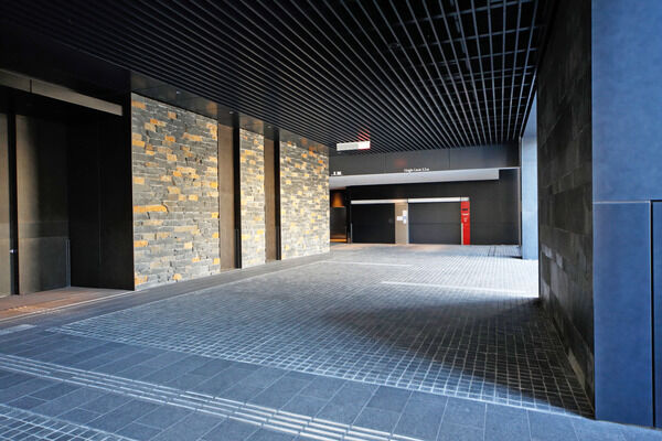 前面通りから奥まったメインエントランスには3種の黒色天然石を配し、重厚感を演出。