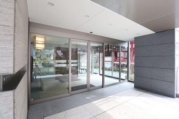 社の緑と調和する天然の御影石を外観やエントランスなどに使用しています。		