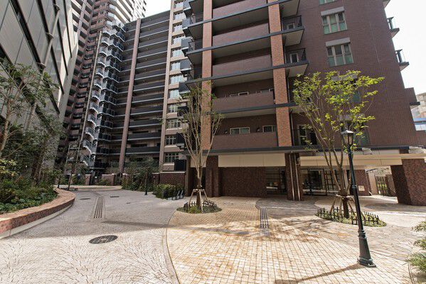 中央広場には石畳調の路地に街路樹や木々を配置。昼夜楽しめる外構のデザインに。	