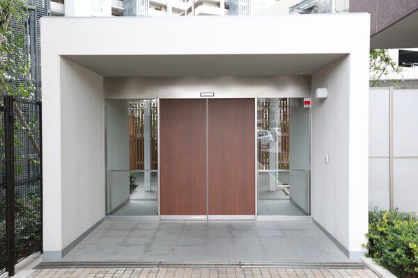 温もりある木調ドアが周囲の緑と調和し、訪れる人をあたたかく迎える。		