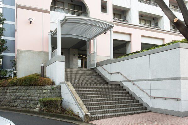 大きな白い庇が目を惹くエントランスアプローチ。		 大きな白い庇が目を惹くエントランスアプローチ。