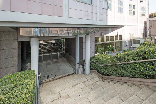 鮮やかな緑のアプローチに導かれ、透明感のあるエントランスへ。