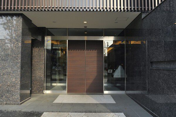 上質な天然石の質感と木調ドアが洗練された雰囲気を醸し出すエントランス。		