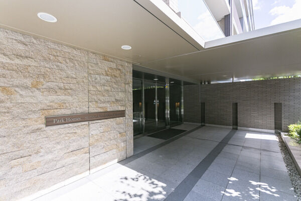 御影石貼りのウェルカムウォールが迎える、フォーマルな雰囲気のメインエントランス。