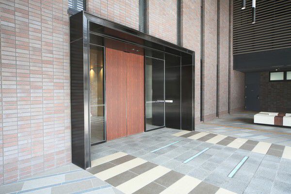 シックな門構えと木調ドアが品格を湛えて訪れる人を迎えるエントランス。		