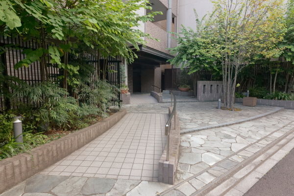 敷地北側の歩道から続く、優雅な曲線で構成されるサブエントランスへのアプローチ。