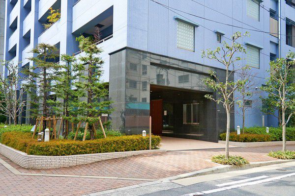 街路樹と植栽の緑が華やかに足元を彩るアプローチ。