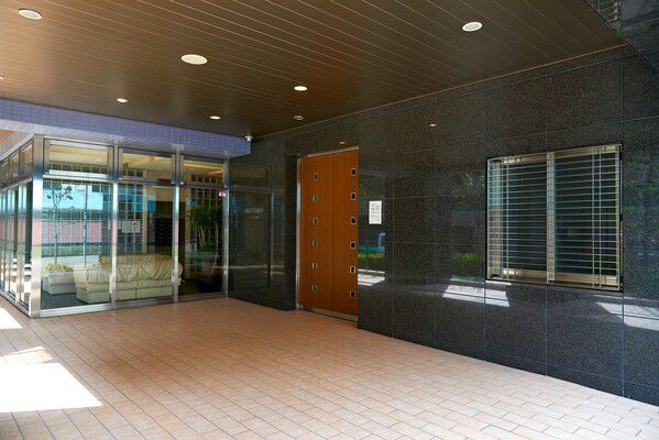 木調ドアと御影石の上質な素材感が美しいエントランス。