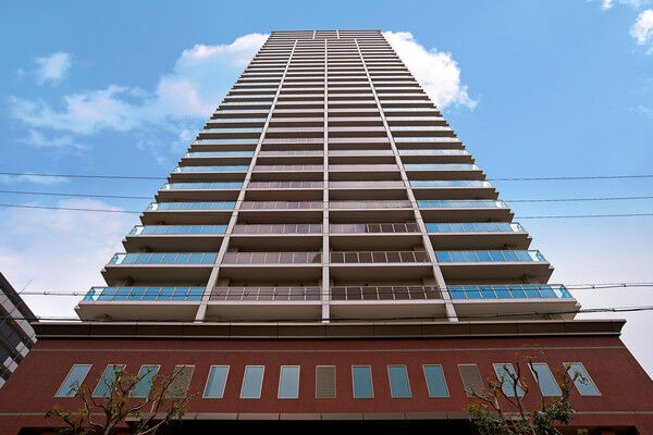 【ヴィークタワーOSAKA】薄いベージュ系を基調とした、シンメトリーな外観デザイン。