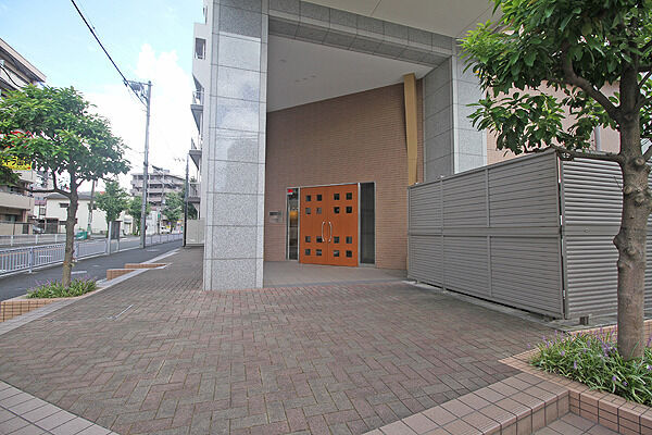 御影石貼りのエントランスファサード、インターロッキング舗装のアプローチ。