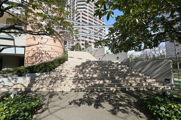 アプローチに設けられたタイル貼りの階段を上がり、2階メインエントランスへ。		