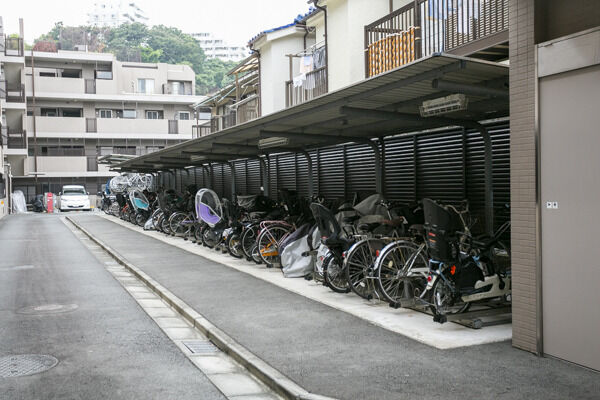 屋外駐輪場。奥にはバイク置場と機械式の屋外駐車場。