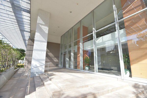 陽光が入り明るく、高い開放感を感じるガラス張りのエントランス。