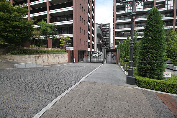 石積みのゲートウォールと針葉樹の列植が、端正な空間を演出するゲートスペース。